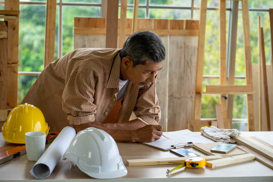 senior Asian man working on wood  work home improvement DIY in workshop recoding streaming online