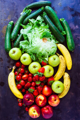 Top view of a fruit and vegetable spread over a black background