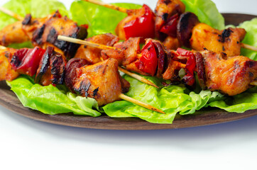 Grilled skewers with chicken, zucchini, mushrooms, peppers and onions served on iceberg lettuce