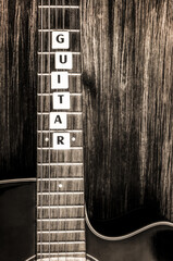 Acoustic guitar in vintage style on wood background