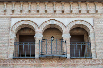 Fototapeta na wymiar modern brick facade with three mudejar style arches on the balcony