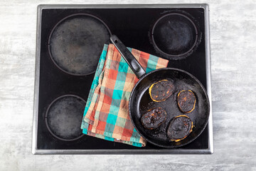 electric stove. Induction. There is a frying pan with food on it. The food is burnt.