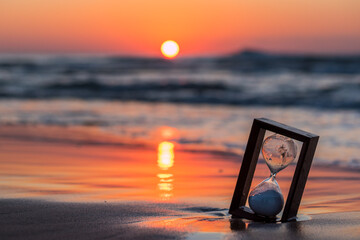 Reloj de arena en la playa al amanecer