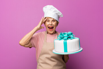mature beautiful old woman looking happy, astonished and surprised, smiling and realizing amazing and incredible good news