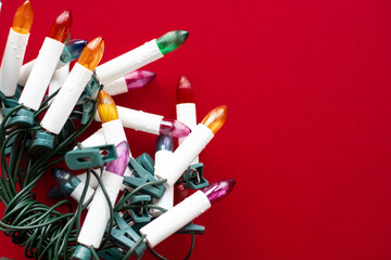 Colorful lights for a Christmas tree on a red background