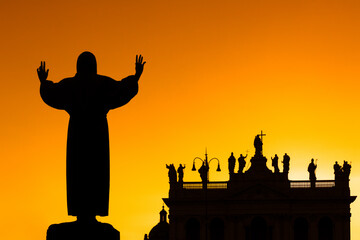Backlight of the facade of the Basilica of San Giovanni, with the statue of Saint Francis of Assisi...