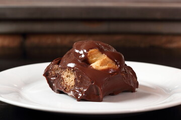 Choux pastry ball with custard filling and chocolate sauce icing