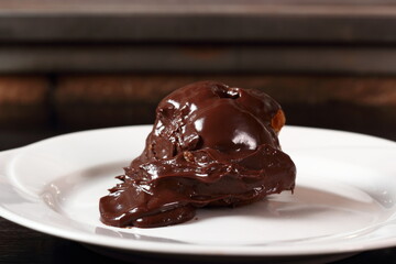 Choux pastry ball with custard filling and chocolate sauce icing