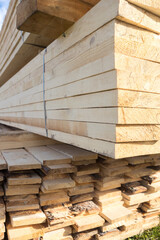 Wooden boards are stored outdoors. Wood texture