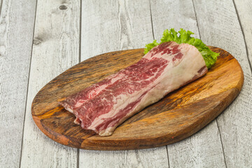 Raw beef bacon over wooden board