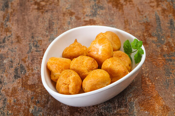 Sweet tasty profiteroles heap in the bowl