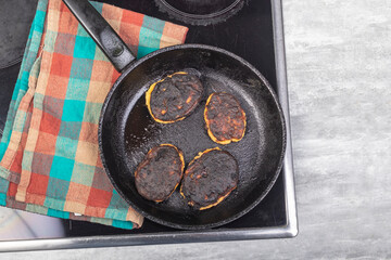 electric stove. Induction. There is a frying pan with food on it. The food is burnt.