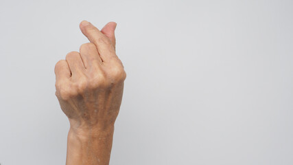 Senior or older woman is doing mini heart hand sign on white background.