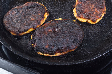 electric stove. Induction. There is a frying pan with food on it. The food is burnt.