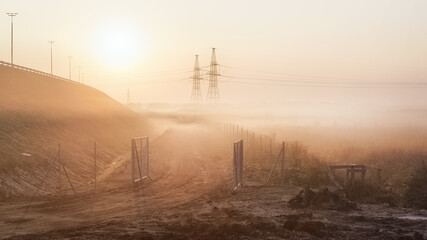 Industrial landscape at foggy dawn