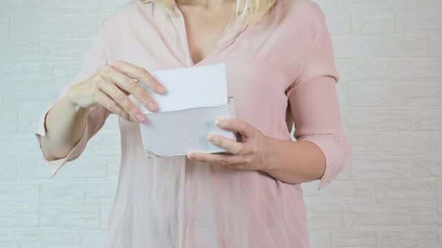Woman opening a cartboard box, parcel and taking some electrical gadget, appliance, device out of it, unpacking and unboxing concept