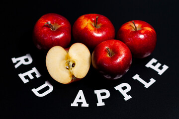 In the center of the screen is a pile of whole fruits and half a fresh apple.