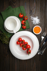 The dishes are laid out on a wooden table. Cherry, grass, utensils, sea salt
