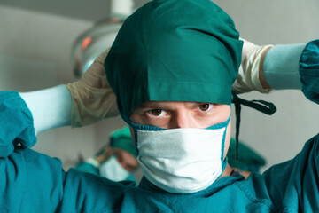 Portrait of Caucasian surgeon doctor wearing surgical mask preparing to perform operation in...