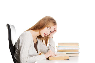 Bored and tired casual student woman sitting by the desk and lea