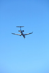 Fototapeta na wymiar Rear view of a landing plane against the clear blue sky.