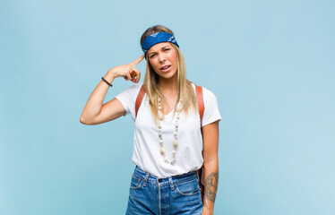 young pretty hippie woman feeling confused and puzzled, showing you are insane, crazy or out of...