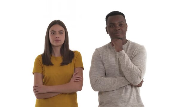 Portrait of cranky Caucasian woman and her confused African boyfriend. Human emotions concept. Isolated on white background