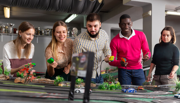 People playing with slot car racing activity. High quality photo