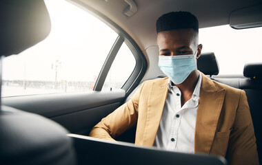 Young Businessman Wearing Mask Working On Laptop In Back Of Taxi During Health Pandemic