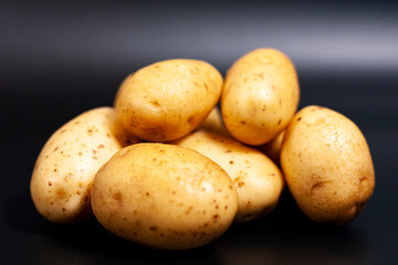 In the center of the screen is a closeup of a pile of unpeeled fresh potatoes. 