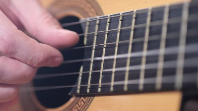 Play the guitar: detail of hands who plays guitar. cloce up