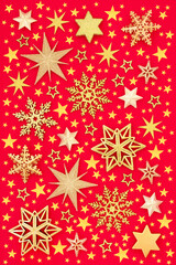 Christmas design of gold stars & snowflakes on red background. Abstract composition for Xmas, New Year & holiday season. Flat lay top view.