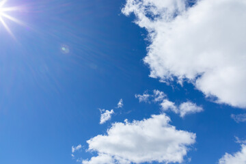 The rays of the sun on blue sky with cumulus clouds