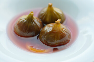 Closeup shot of three figs in syrup dessert