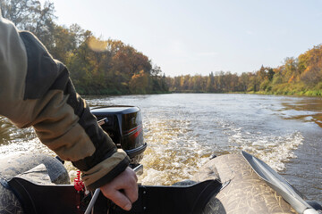 a fisherman drives a boat engine