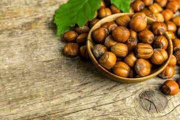 hazelnuts on wooden table, top view. Food background. Heap of many whole ripe brown hazel nuts. Vegan food.