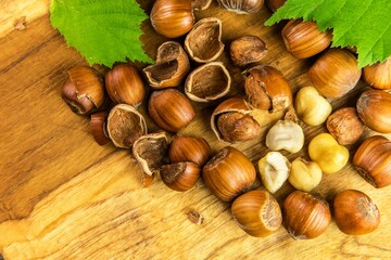 hazelnuts on wooden table, top view. Food background. Heap of many whole ripe brown hazel nuts. Vegan food.