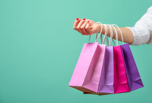 Shopping bags on womans hand. Woman shopping with colored paper bags.