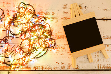 Black easel in the New Year theme. Christmas lights. Place for text. Black mini easel.