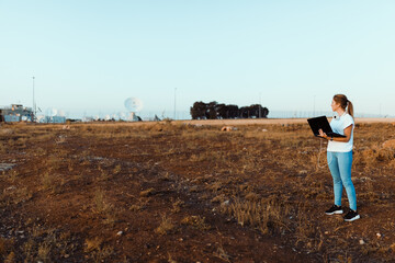 Young woman with her laptop communicates with antennas