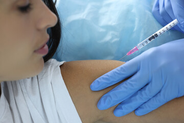 Doctor gives patient an injection in shoulder. Mass vaccination of the population against dangerous diseases concept