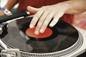 dj hand on black record with red label