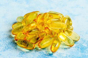 Fish oil capsules on a blue background - omega 3 vitamins and health concept
