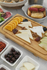 Breakfast table with slices of cheese on a wooden board. Orange juice in jar glass and breakfast foods. Fresh, healthy, light breakfast