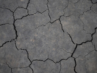 Surface of a grungy dry cracking parched earth for textural background.