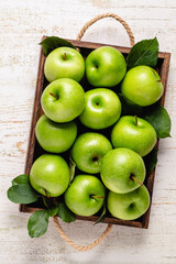 Ripe green apples in wooden box.