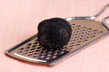 one organic summer truffle on a grater