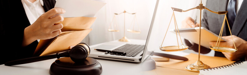 Justice and law concept.Male judge in a courtroom with the gavel, working with, computer and docking keyboard, eyeglasses, on table in morning light