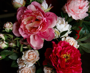 bouquet of artificial peonies on a dark background. Photo close-up