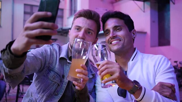 Making stories phone selfie two guys friends hang out drink beer on night city street bar